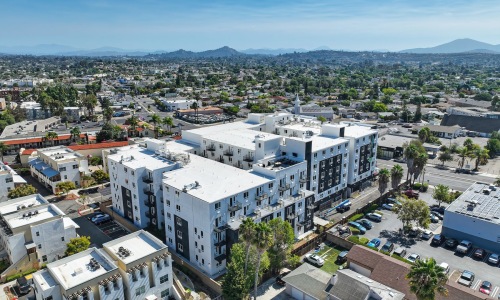 the exterior of a large buildings surrounded by buildings in a town