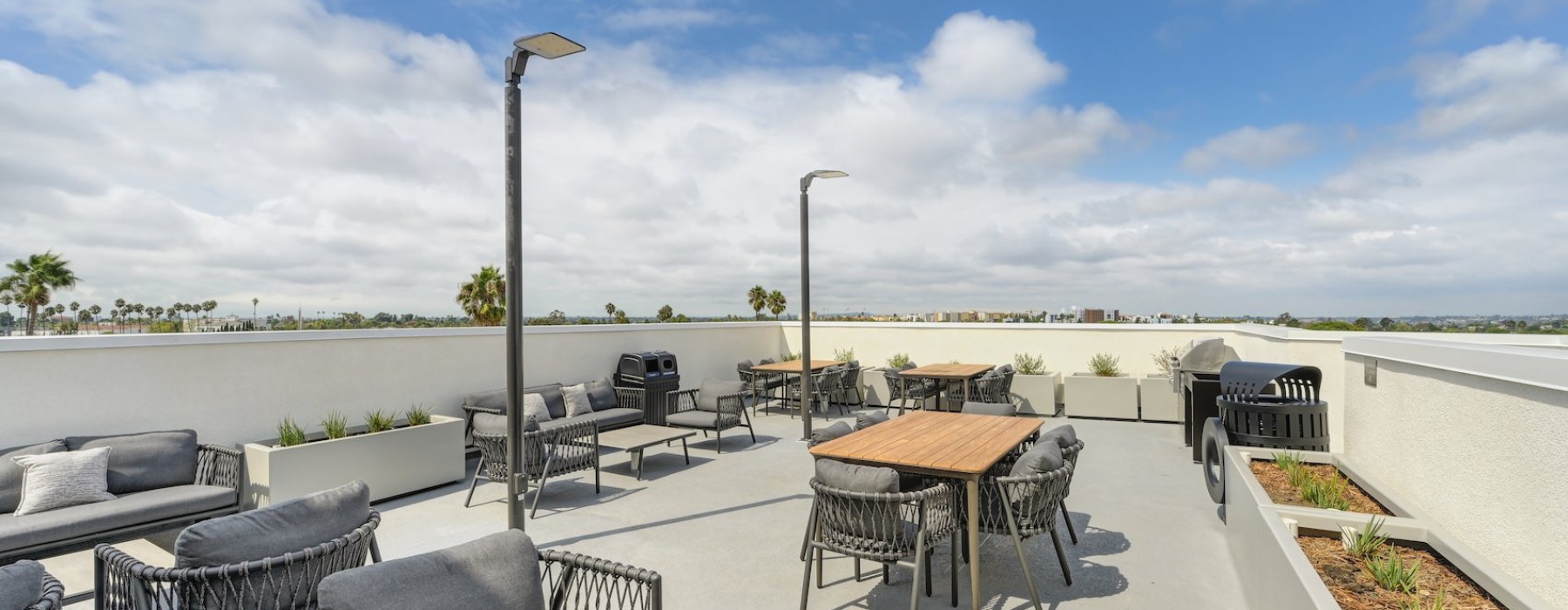 a rooftop lounge with tables and chairs