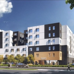 exterior of building with green turf and some seating